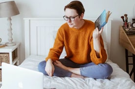 Teenager studying in bed