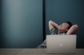 man leaning back in front of laptop.