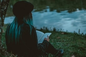 girl reading by a pond.