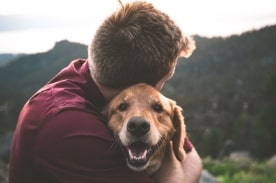 man hugging dog