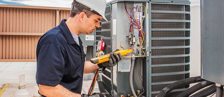 HVACR technician working on commercial air conditioner.